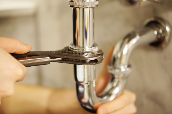 A man repairing a pipe.